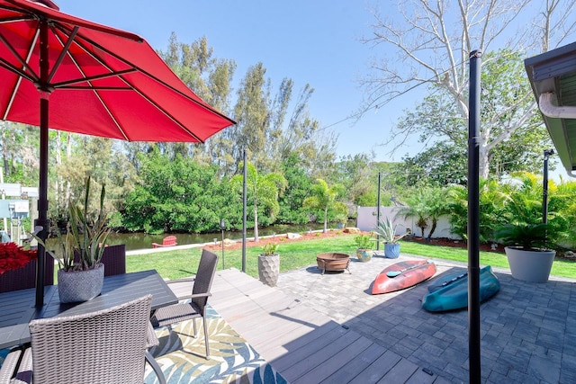 deck with an outdoor fire pit, outdoor dining area, a lawn, and fence