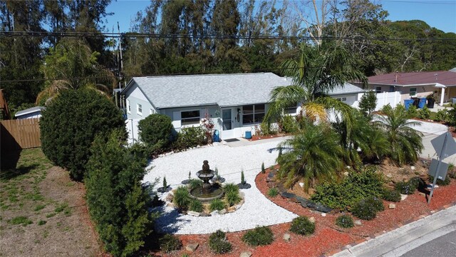 view of front of house featuring a shingled roof and fence