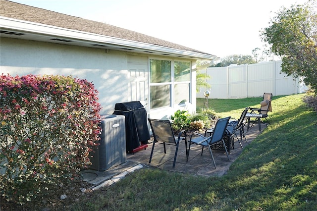 view of yard featuring a patio area, fence, and central air condition unit