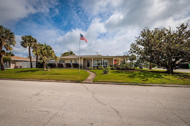 ranch-style home with driveway and a front lawn