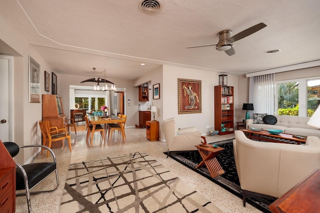 2340 W Bay Isle Dr SE, Saint Petersburg, FL 33705 - living area featuring ceiling fan with notable chandelier, speckled floor, visible vents, and baseboards