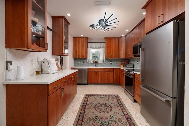 2340 W Bay Isle Dr SE, Saint Petersburg, FL 33705 - kitchen featuring visible vents, brown cabinetry, glass insert cabinets, stainless steel appliances, and light countertops
