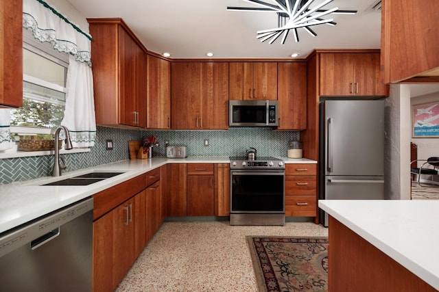 2340 W Bay Isle Dr SE, Saint Petersburg, FL 33705 - kitchen with brown cabinets, a sink, stainless steel appliances, light countertops, and backsplash