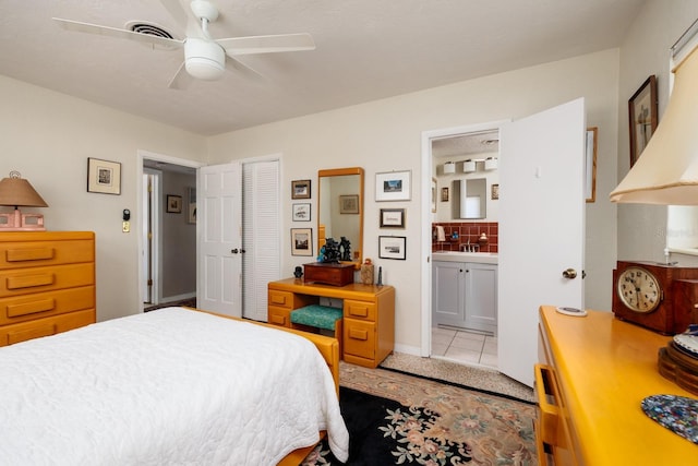 2340 W Bay Isle Dr SE, Saint Petersburg, FL 33705 - bedroom featuring ensuite bathroom, ceiling fan, light tile patterned floors, visible vents, and a closet