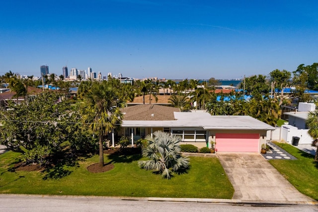 2340 W Bay Isle Dr SE, Saint Petersburg, FL 33705 - view of front of property with driveway, a garage, a view of city, fence, and a front yard