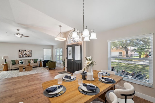 dining room with light wood-type flooring, a ceiling fan, and baseboards