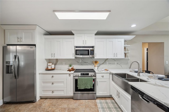 kitchen featuring appliances with stainless steel finishes, white cabinets, a sink, and open shelves