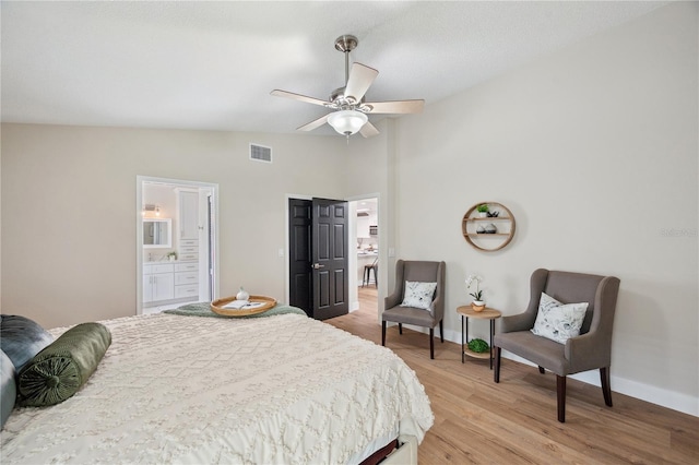 bedroom with vaulted ceiling, light wood-type flooring, visible vents, and baseboards