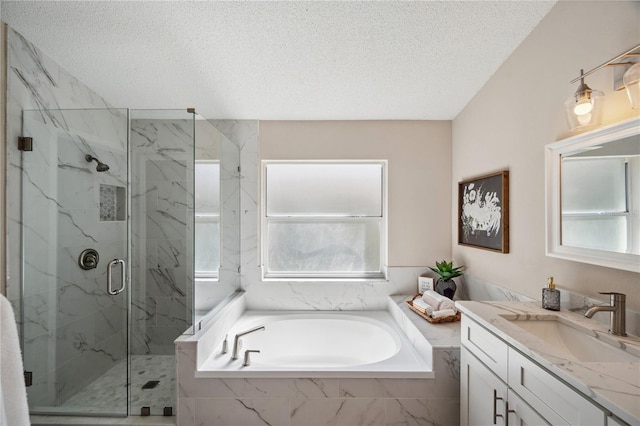 full bathroom with a garden tub, a marble finish shower, a textured ceiling, and vanity