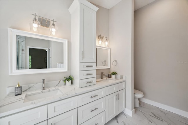 bathroom with double vanity, marble finish floor, baseboards, and a sink