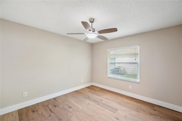 unfurnished room featuring a textured ceiling, baseboards, and wood finished floors