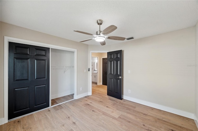 unfurnished bedroom featuring light wood finished floors, baseboards, a ceiling fan, a textured ceiling, and a closet