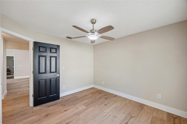 unfurnished room with visible vents, baseboards, a ceiling fan, a textured ceiling, and light wood-style floors