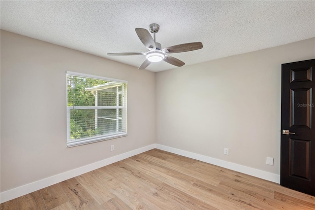 spare room with light wood-style flooring, baseboards, ceiling fan, and a textured ceiling