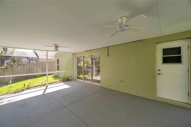 unfurnished sunroom featuring a ceiling fan