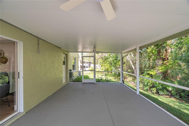 unfurnished sunroom featuring a ceiling fan