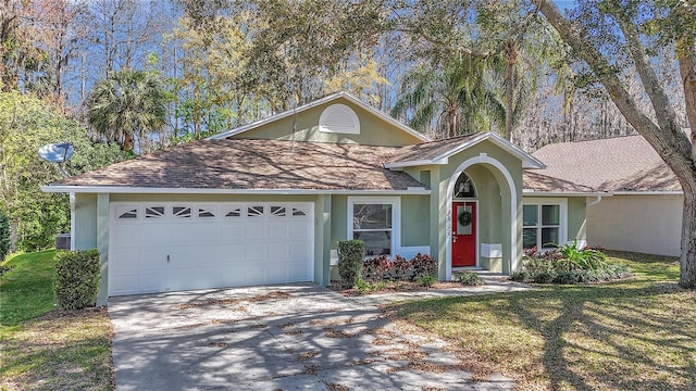 view of front of property featuring roof with shingles, stucco siding, an attached garage, driveway, and a front lawn