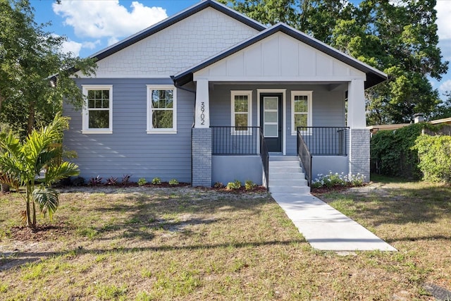 3902 E Henry Ave, Tampa, FL 33610 - bungalow-style house featuring a front yard, board and batten siding, and covered porch