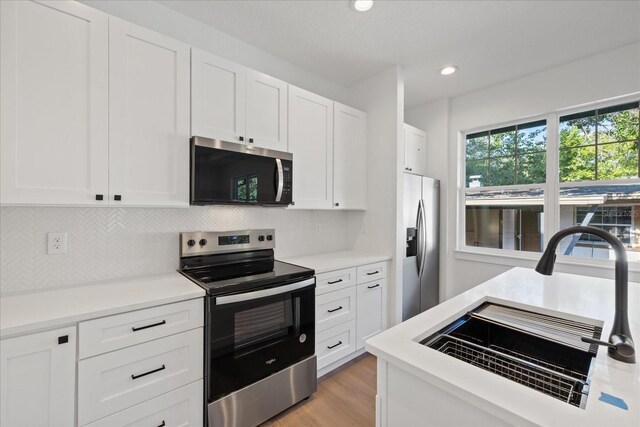 3902 E Henry Ave, Tampa, FL 33610 - kitchen featuring tasteful backsplash, stainless steel appliances, light countertops, and a sink