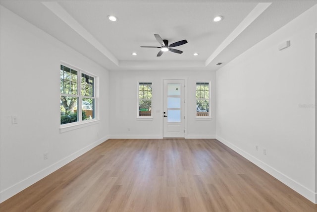 3902 E Henry Ave, Tampa, FL 33610 - interior space featuring a raised ceiling, light wood-style flooring, a ceiling fan, and baseboards