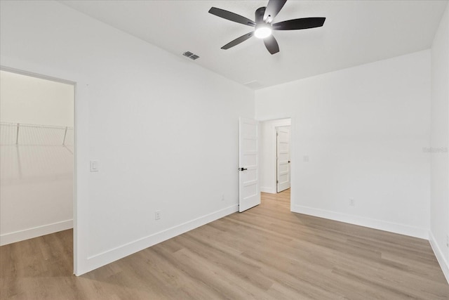 3902 E Henry Ave, Tampa, FL 33610 - unfurnished bedroom with light wood-style flooring, visible vents, baseboards, a spacious closet, and ceiling fan