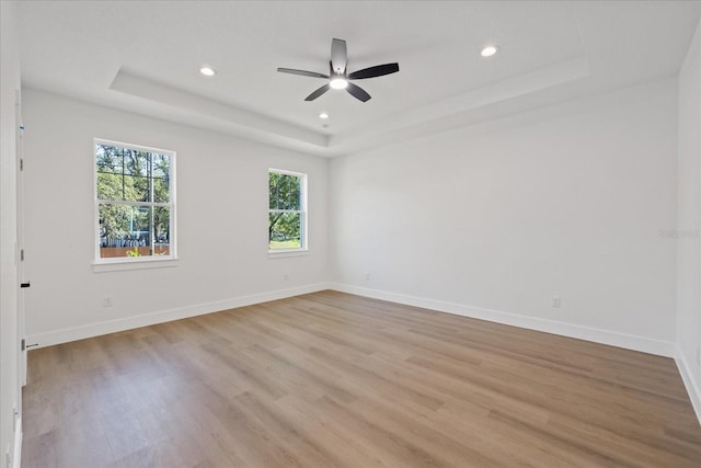 3902 E Henry Ave, Tampa, FL 33610 - empty room with recessed lighting, a tray ceiling, a ceiling fan, light wood-type flooring, and baseboards