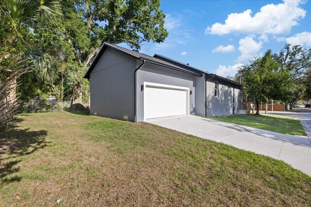 3902 E Henry Ave, Tampa, FL 33610 - view of home's exterior with a yard, an attached garage, driveway, and stucco siding