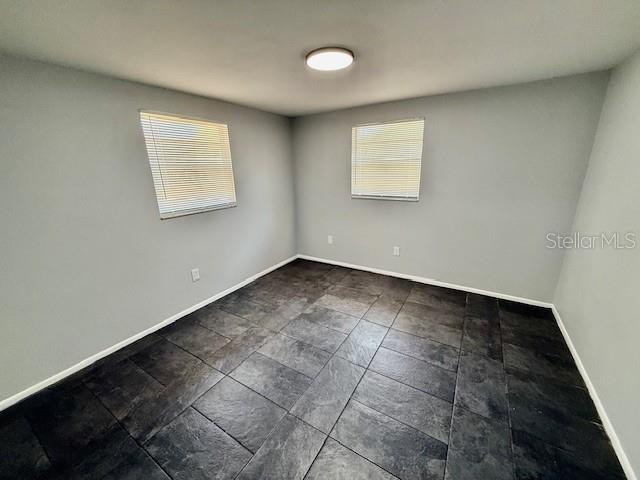 unfurnished room with baseboards