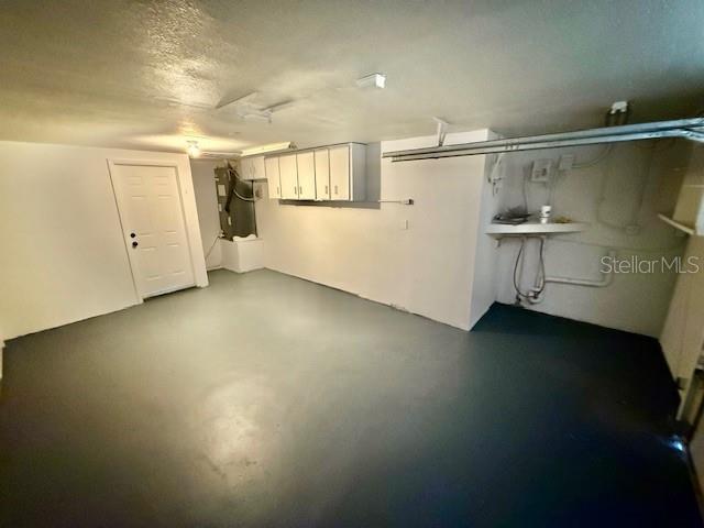 basement with heating unit and a textured ceiling