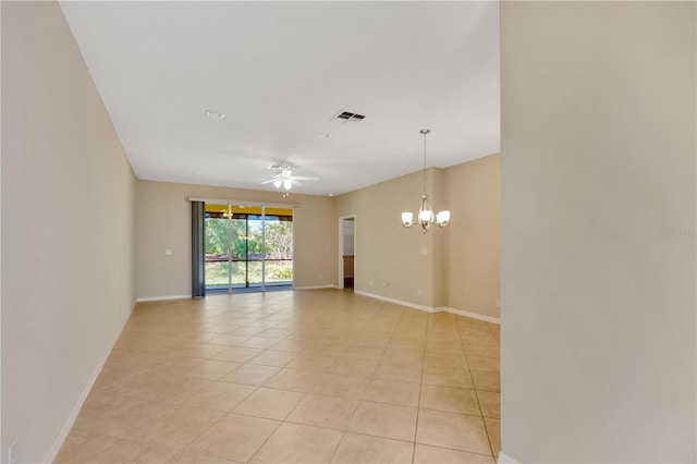 empty room with ceiling fan with notable chandelier, visible vents, baseboards, and light tile patterned floors