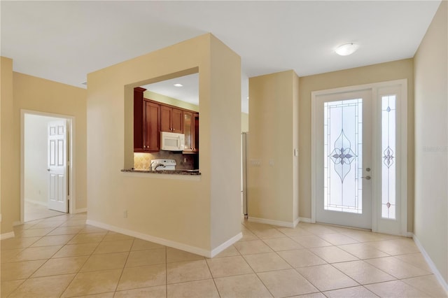 entryway featuring light tile patterned floors and baseboards