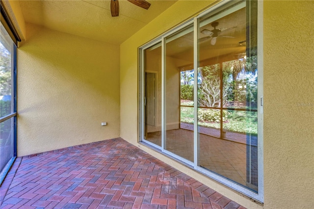 unfurnished sunroom with ceiling fan