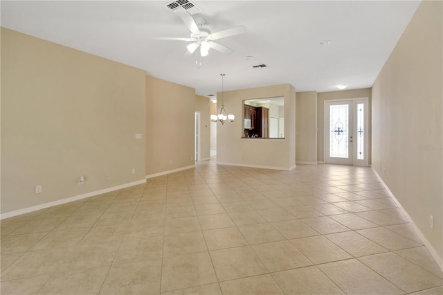 spare room featuring light tile patterned floors, baseboards, visible vents, and ceiling fan with notable chandelier