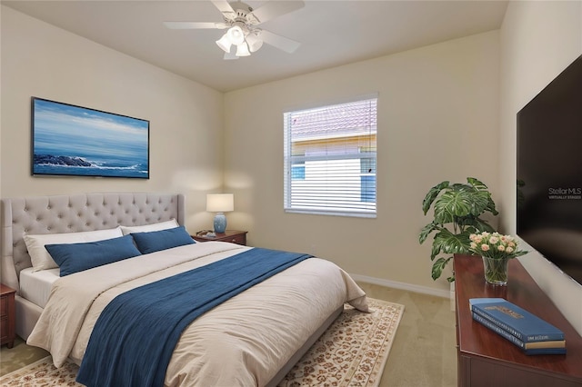 bedroom with baseboards, ceiling fan, and light colored carpet