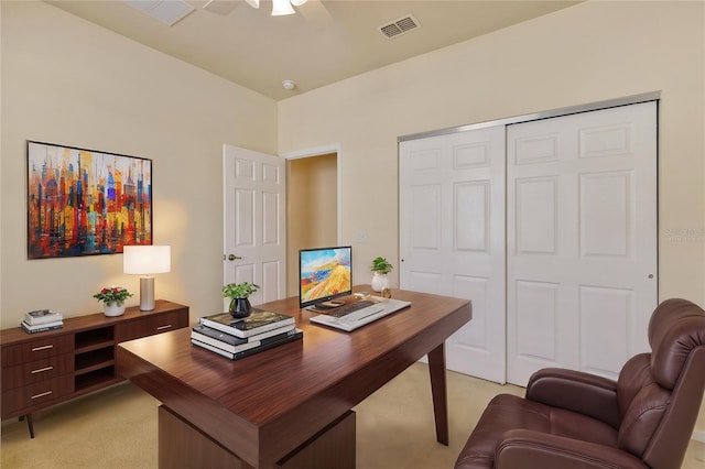 office area with light colored carpet, visible vents, and ceiling fan