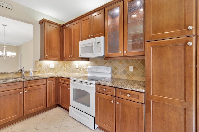 16232 Amethyst Key Dr, Wimauma, FL 33598 - kitchen featuring white appliances, backsplash, brown cabinetry, and a chandelier