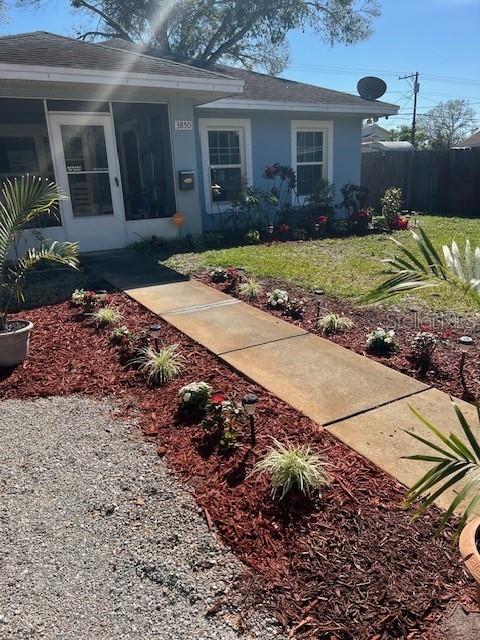 view of front facade with a front yard, fence, and stucco siding