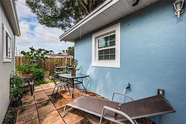 view of patio with outdoor dining area and fence