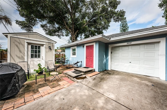 view of front of property featuring concrete driveway, an attached garage, fence, and stucco siding