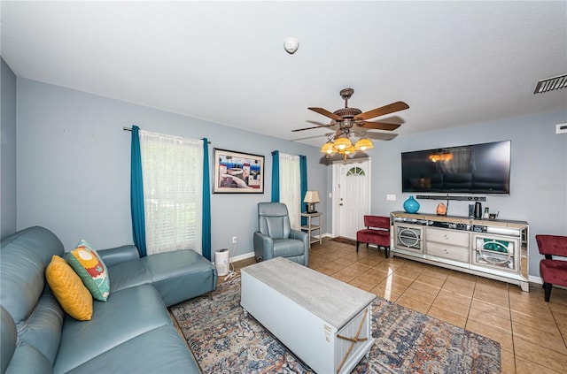 living room with a ceiling fan, tile patterned floors, baseboards, and visible vents