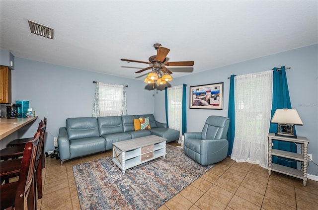 living room with light tile patterned floors, visible vents, and ceiling fan