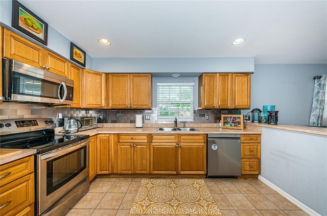 kitchen with light tile patterned floors, stainless steel appliances, light countertops, and a sink