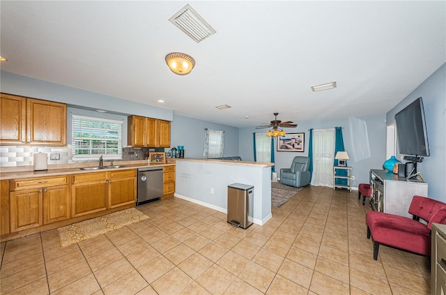 kitchen featuring visible vents, backsplash, open floor plan, stainless steel dishwasher, and a sink