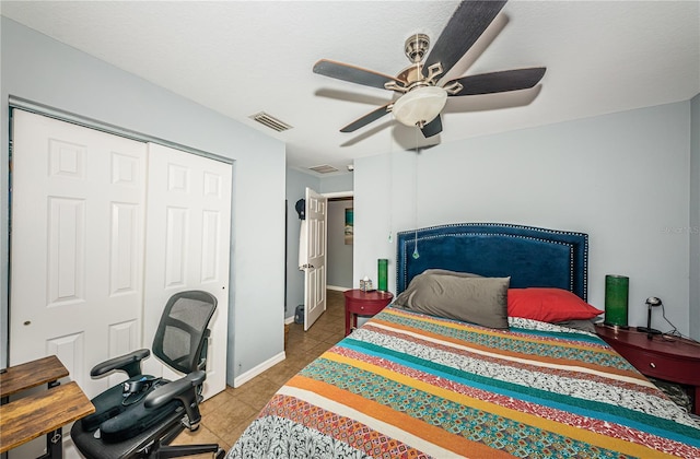 bedroom with tile patterned flooring, visible vents, ceiling fan, baseboards, and a closet