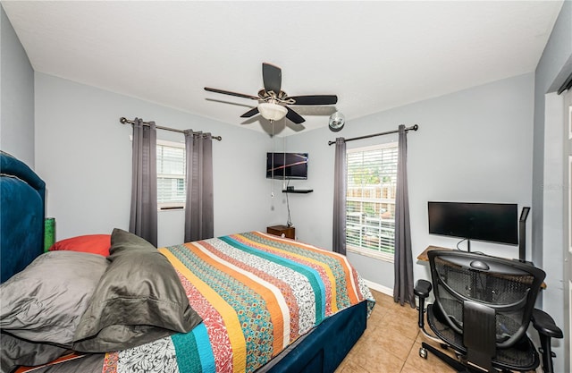 bedroom featuring baseboards, light tile patterned flooring, and a ceiling fan