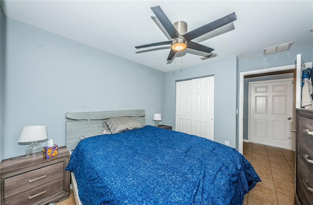 tiled bedroom featuring a ceiling fan, visible vents, and a closet