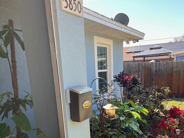 exterior space with stucco siding and fence