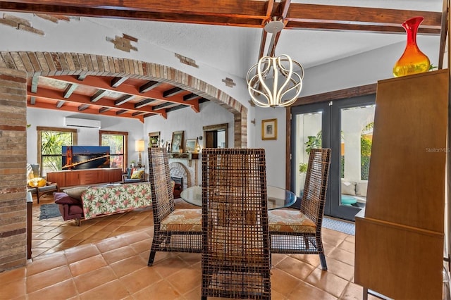 dining area featuring arched walkways, tile patterned flooring, a fireplace, a wall mounted AC, and beam ceiling