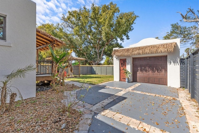 view of yard featuring a garage, an outdoor structure, and fence