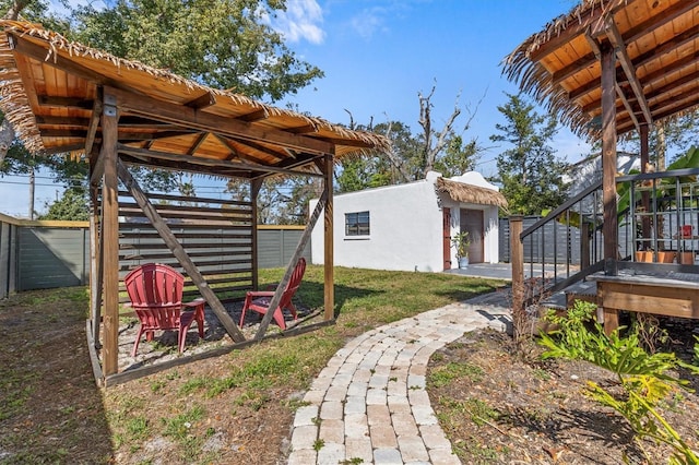 view of yard with stairs, fence, and an outdoor structure